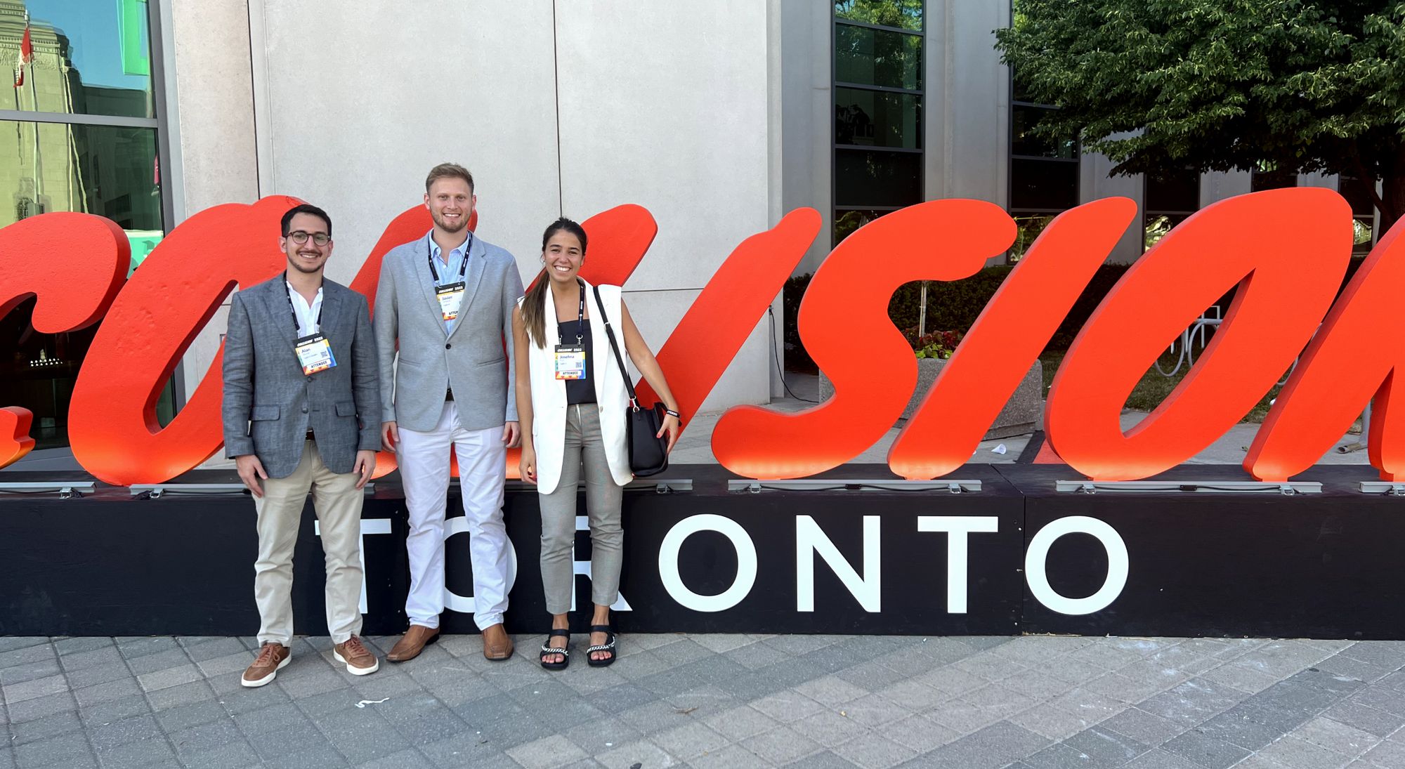 Alan Brande, Javier Lempert and Josefina Ruiz in front of the Collision Toronto's sign.