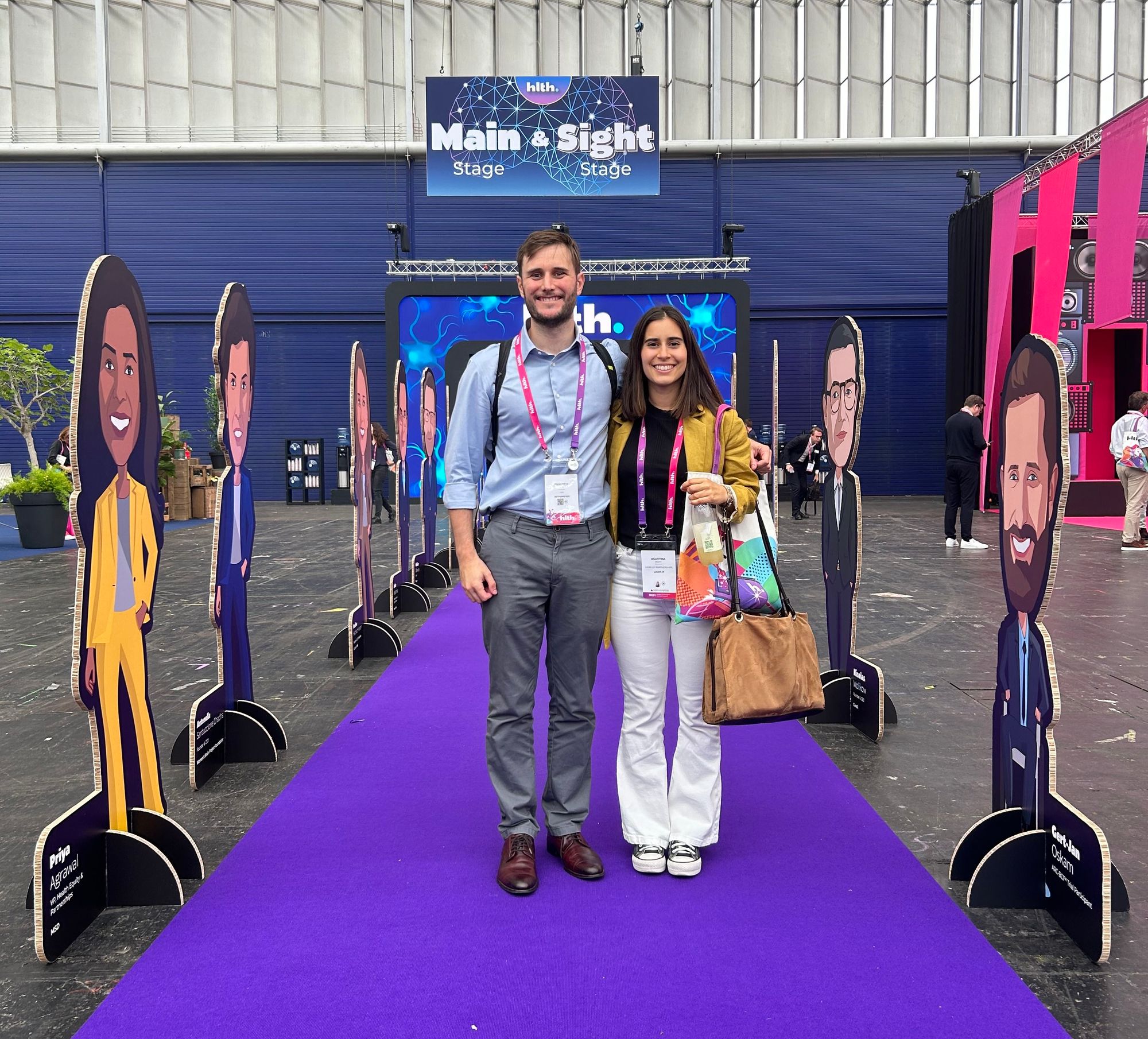 Agus and Federico standing, smiling in front of HLTH Europe's entrance.